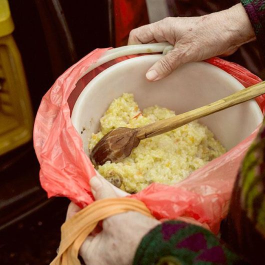 Frisch zubereitete Mahlzeiten werden an Bedürftige abgegeben